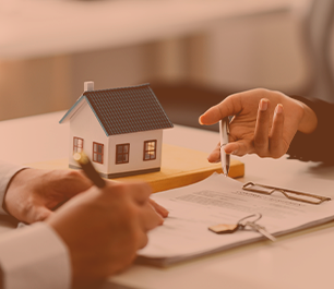 foto pessoas analisando papéis e casinha ao lad