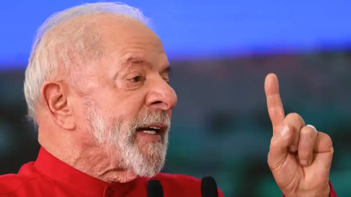 Close-up do Presidente Lula, vestindo camisa vermelha, gesticulando durante um discurso.