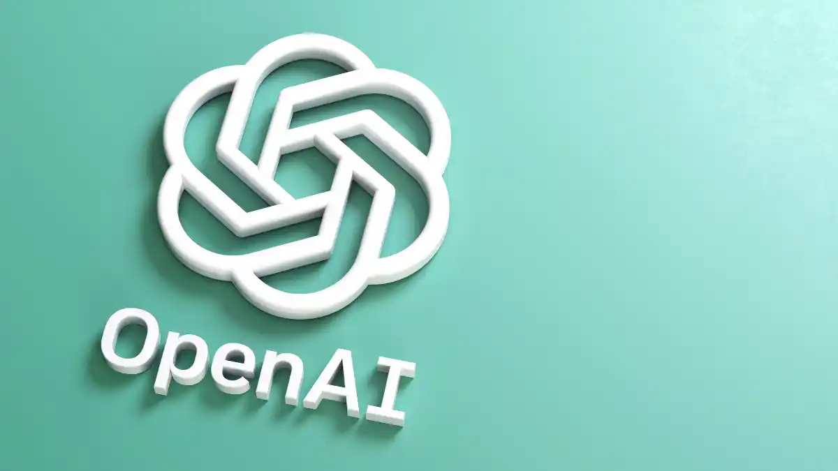 O logotipo 3D da OpenAI (com o nó e o nome da empresa) em uma superfície verde-água, simbolizando o IPO da criadora do ChatGPT.