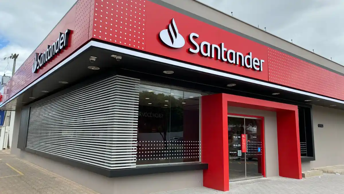 Fachada de uma agência do Banco Santander com o logo vermelho e branco em destaque, representando o balanço do 3º trimestre de 2025.