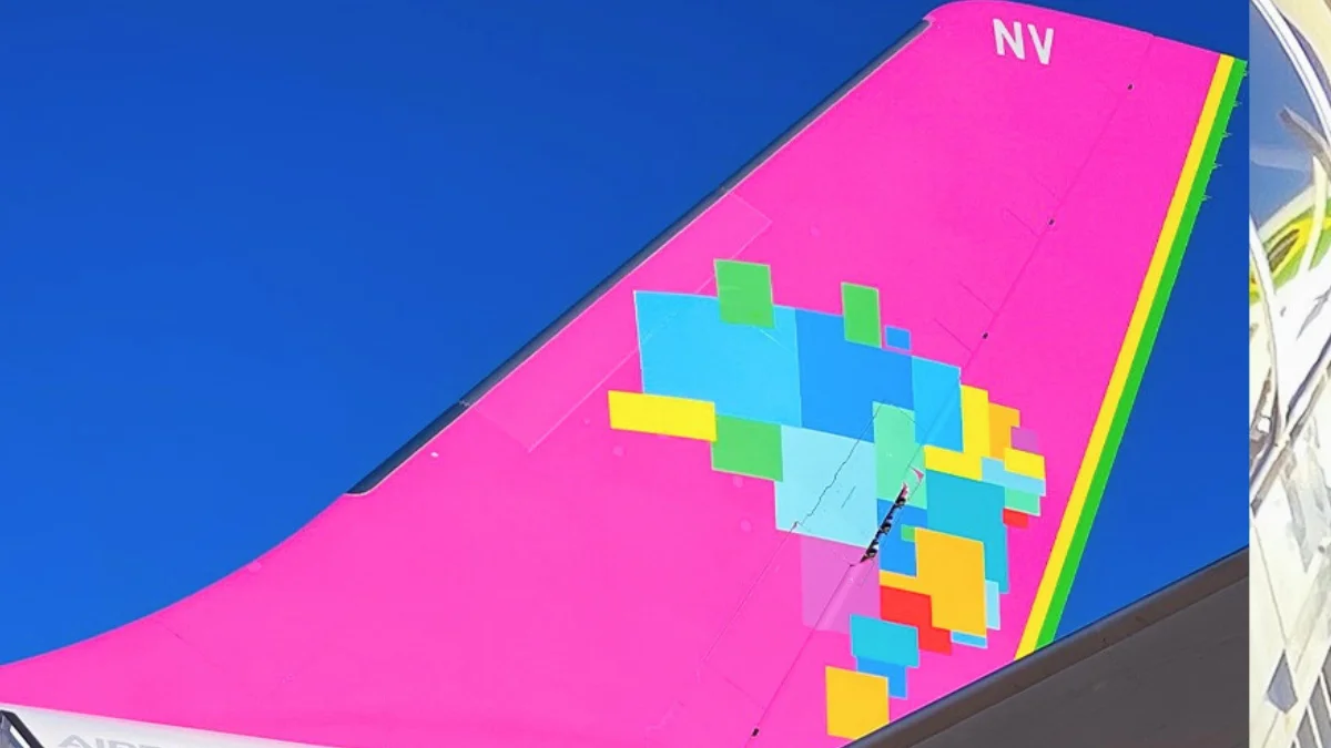Cauda de uma aeronave da Azul (AZUL4) com o mapa do Brasil estilizado em cores vibrantes (rosa e azul), ilustrando o prejuízo da companhia no 3º trimestre de 2025.