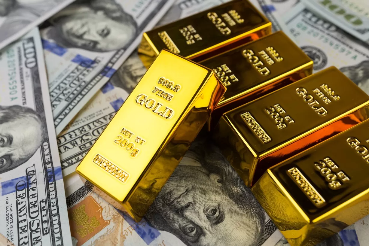 ouro ou dólar: imagem de barras de ouro e notas de dólares