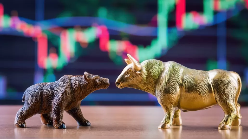 rali das bolsas: imagem de touro e urso, à frente de gráfico de investimento