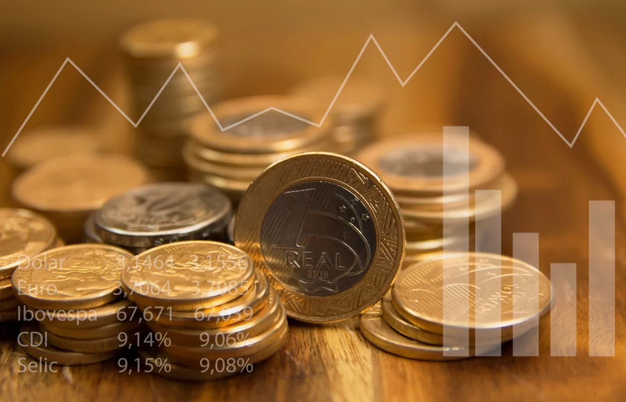 Selic ainda a 15%: quais os melhores investimentos. Foto de pilhas de moedas e gráficos projetados, onde se lê Brasil, PIB, Selic