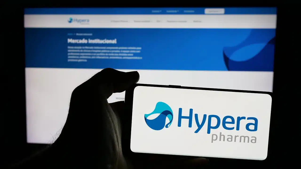 Logo da Hypera em tela de celular em primeiro plano