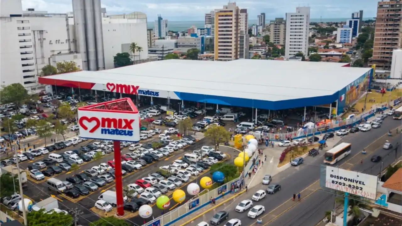 Vista aérea de loja Mix Mateus com totem de identificação e estacionamento movimentado, ilustrando matéria sobre a alta das ações no balanço do Grupo Mateus 2T26.